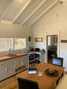 cocina y comedor con mesa de madera en Paratu Farm Cottage in a quiet rural setting., en  Waipukurau