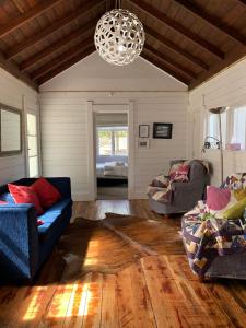 ein Wohnzimmer mit 2 Sofas und einem Kronleuchter in der Unterkunft Paratu Farm Cottage in a quiet rural setting. in  Waipukurau
