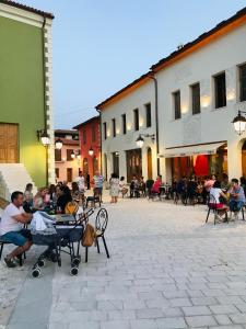 un grupo de personas sentadas en mesas en un patio en Foleza - Bed and breakfast, en Vlorë
