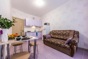 a living room with a couch and a kitchen at Стильные апартаменты,метро Вырлица,метро Харьковская in Kyiv