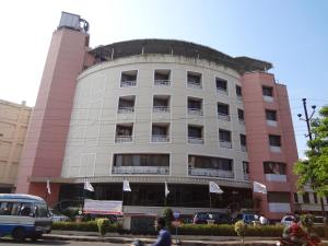 a pink building with flags in front of it at Daspalla Executive Court in Visakhapatnam