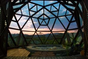a glass dome with a hot tub in the middle at Nacimiento Glamping in San Agustín