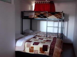 a bedroom with two bunk beds and a bed with a quilt at Marvelous Hostel Cusco in Cusco
