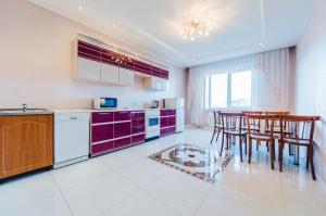 a kitchen with purple cabinets and a table and chairs at Dekabrist Apartment at anokhina 93 in Chita