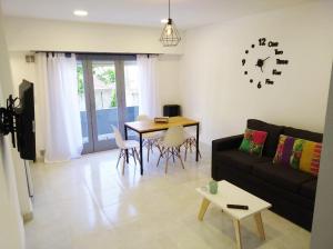 a living room with a couch and a table and a clock at Departamentos Necochea Playa in Necochea