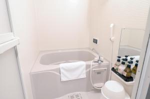 a bathroom with a tub and a toilet and a sink at Stay SAKURA Kyoto Gion North in Kyoto