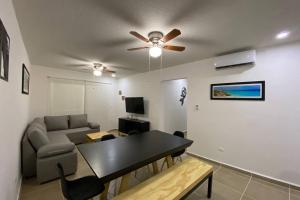 坎昆Departamento Dream Lagoons Cancún的带吊扇和桌子的客厅