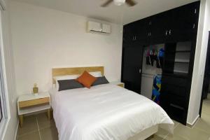 坎昆Departamento Dream Lagoons Cancún的卧室配有白色的床和冰箱。 更多33张照片