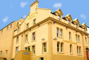 um grande edifício amarelo com as palavras biblioteca Guilford em The Golden Lion Hotel em Maryport