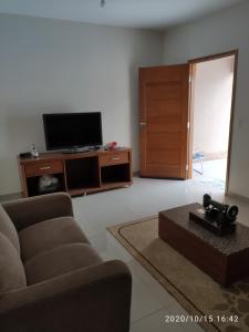 a living room with a couch and a tv at Casa aconchegante perto da Uel in Londrina