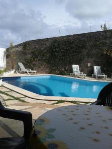 einen Pool mit 2 Stühlen und einem Tisch in der Unterkunft PontaNegra PontadoSolluciene Apartamento aconchegante Oh Vida Boa in Natal