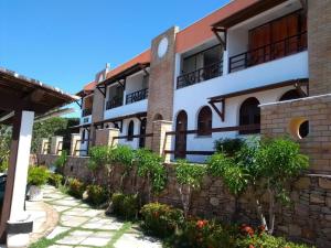 a building with a stone wall next to a sidewalk at PontaNegra PontadoSolluciene 4B in Natal