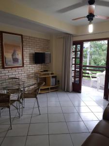 a living room with a table and a tv at Apartamento Bombinhas in Bombinhas