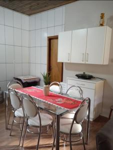 ein Esszimmer mit einem Tisch und Stühlen sowie eine Küche in der Unterkunft Sítio Elias in Lauro Müller