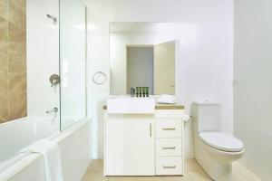ein weißes Bad mit einem WC und einem Waschbecken in der Unterkunft Premium 2 Bedroom Garden Apartment in Warrawee