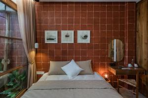 a bedroom with a bed and a tiled wall at LIMDIM HERE in Hue