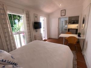 um quarto com uma cama, uma secretária e uma mesa em Guest House at 118 by PWM Architects em Joanesburgo