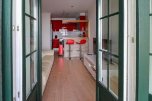 una cocina con armarios rojos y taburetes rojos en una habitación en Parede Flats, en Parede