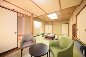 sala de estar con 2 sillas y mesa en Naruko Fuga en Osaki