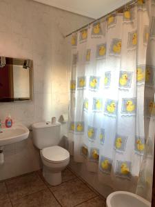 een badkamer met een douchegordijn, een toilet en een wastafel bij Apartamentos Rurales Hermanos Alcalá in Ibdes