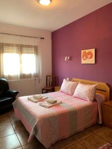 a bedroom with a bed with purple walls at Apartamentos Rurales Hermanos Alcalá in Ibdes