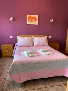 een slaapkamer met een groot bed met een paarse muur bij Apartamentos Rurales Hermanos Alcalá in Ibdes