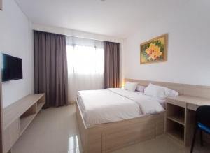 a bedroom with a bed and a desk and a window at Mendjangan Mansion in Jakarta +34 photos