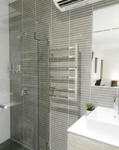 a glass shower in a bathroom with a sink at Copper City Motel in Mount Isa