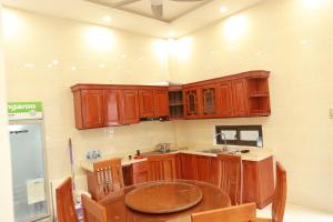 a kitchen with wooden cabinets and a wooden table at Gold Hotel in Cao Bằng