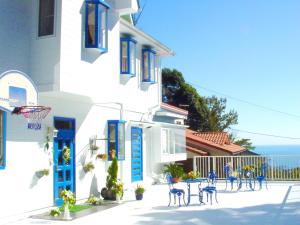 a white building with blue doors and tables and chairs at Kamo-gun - Hotel / Vacation STAY 41222 in Okawa