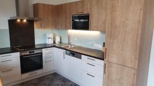 eine Küche mit weißen Geräten und Holzschränken in der Unterkunft Ferienwohnung Lenz in Bad Hofgastein