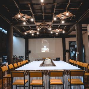 una sala de conferencias con una mesa grande y sillas en Saung Balibu Hotel en Lembang