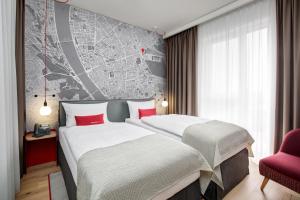 duas camas num quarto de hotel com um mapa na parede em IntercityHotel Budapest em Budapeste
