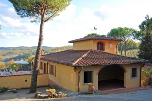 uma pequena casa amarela com uma árvore em frente em Poggio d'Oro em San Donato in Poggio