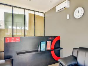 een kantoor met een klok aan de muur en een stoel bij Collection O 92440 Urban Town Apartment Karawang in Telukjambe