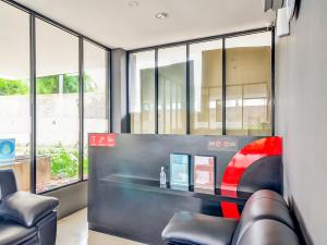 a waiting room with a counter and chairs and windows at Collection O 92440 Urban Town Apartment Karawang in Telukjambe