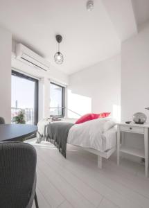 Habitación blanca con cama y escritorio en 高層階からの眺望確約Forest Yoyogi Park 新宿まですぐの京王線幡ヶ谷駅徒歩4分, en Tokio