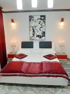 a bedroom with a large white bed with red pillows at Amaraz Center in Sibiu