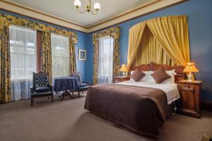 a bedroom with a bed with blue walls and windows at Orana House in Hobart