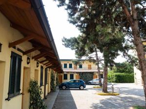 a car parked in front of a building with trees at Hotel Fiera Rho in Rho