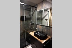 a bathroom with a sink and a shower at Caveau Contemporain KV'O37 in Arbois