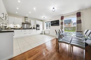 a kitchen and dining room with a glass table and chairs at London Heathrow Living Holywell Serviced Houses - 3 and 4 bedrooms By Ferndale in Stanwell