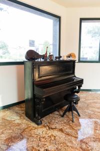 un viejo piano sentado en una habitación con un taburete en Hotel Fiera Rho, en Rho