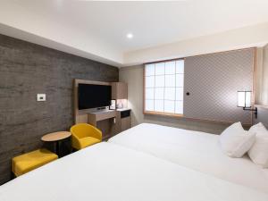 a hotel room with a large bed and a tv at Asakusa Tobu Hotel in Tokyo