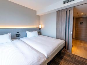 Postel nebo postele na pokoji v ubytování Asakusa Tobu Hotel