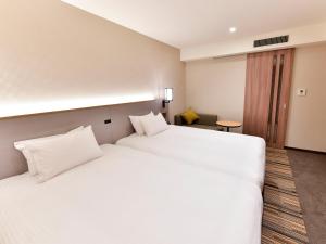 Postel nebo postele na pokoji v ubytování Asakusa Tobu Hotel