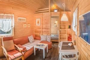 a living room of a log cabin with a couch and a table at Tiny House Lavender in Podtureň