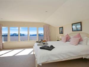 a bedroom with a large white bed with pink pillows at Warrington Park in Berrima