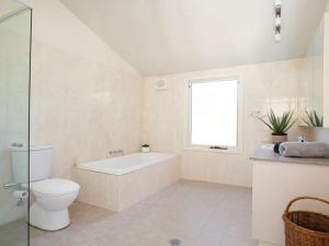 a bathroom with a tub and a toilet and a window at Warrington Park in Berrima