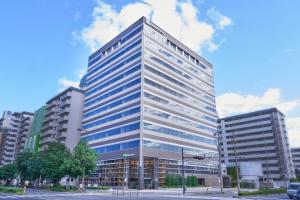 大阪Holiday Inn & Suites Shin Osaka by IHG的一座高大的办公室大楼,有很多窗户